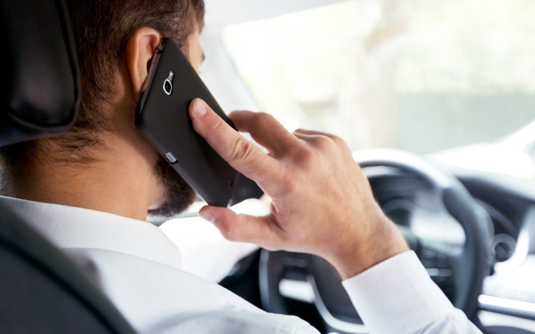 Man talks on cellphone while driving.
